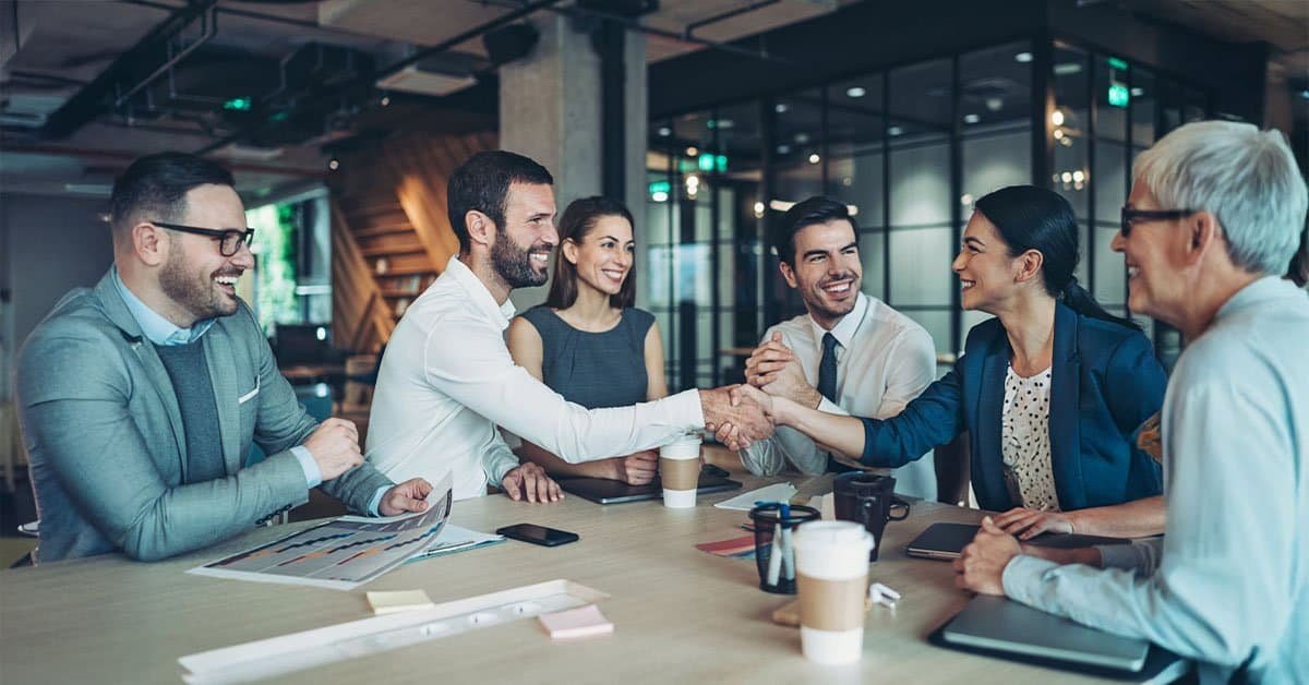 A team of business owners smiling confidently after choosing a modern bookkeeping plan to achieve financial clarity.
